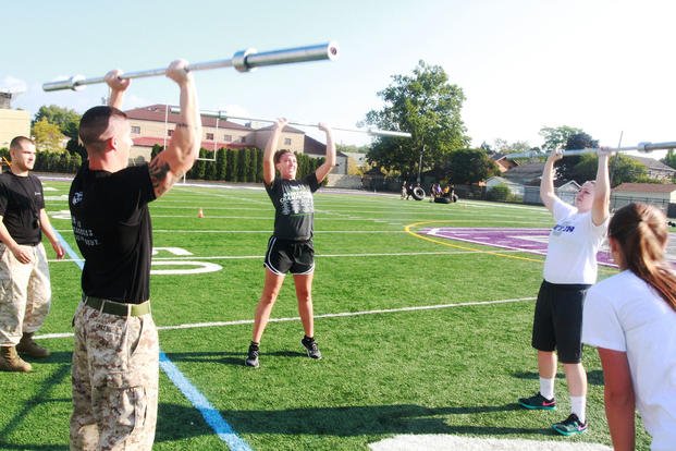Recruiting Station Charleston Marines complete a set of barbell presses alongside a member of the Capital University women’s basketball team in Columbus, Ohio, as part of a leadership seminar.