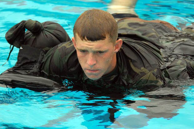 A seaman apprentice uses his uniform as a floatation device during a training exercise in the combat training tank at Naval Amphibious Base Coronado. 