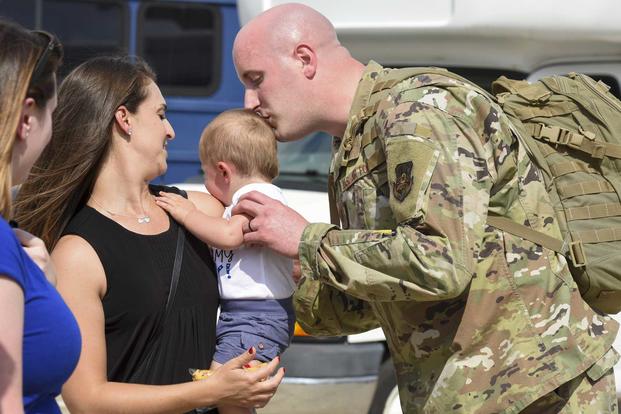 Air National Guardsman kisses his baby after returning from a deployment.
