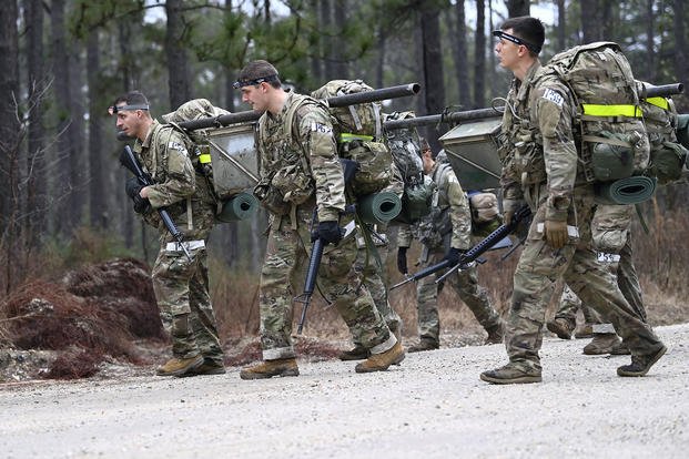 Psychological operations candidates carry a weighted ammunition can during Psychological Operations Assessment and Selection.