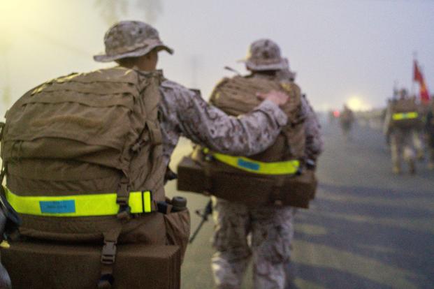 U.S. Marine Corps recruits motivate each other during a 5K hike.