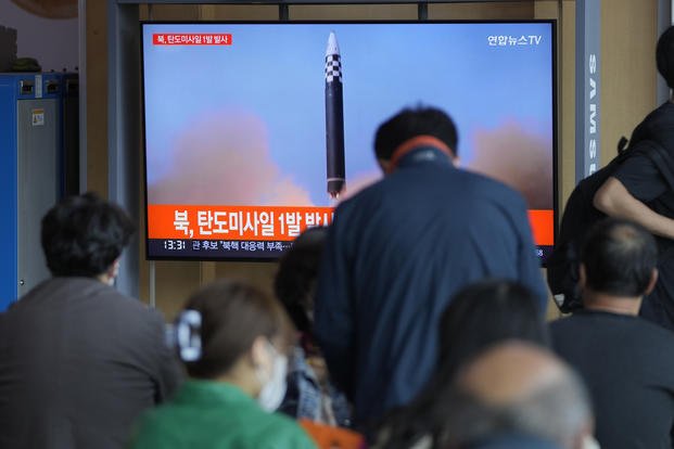 news reporting about North Korea's missile launch with file footage, at a train station in Seoul