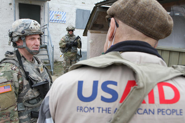 a U.S. Army Reserve officer talks with a representative of USAID in Germany. 