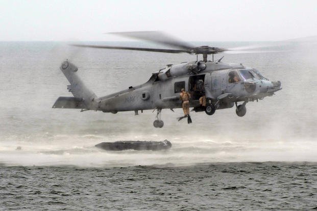 U.S. Navy SEALs drop into the ocean from an HH-60H Seahawk helicopter.