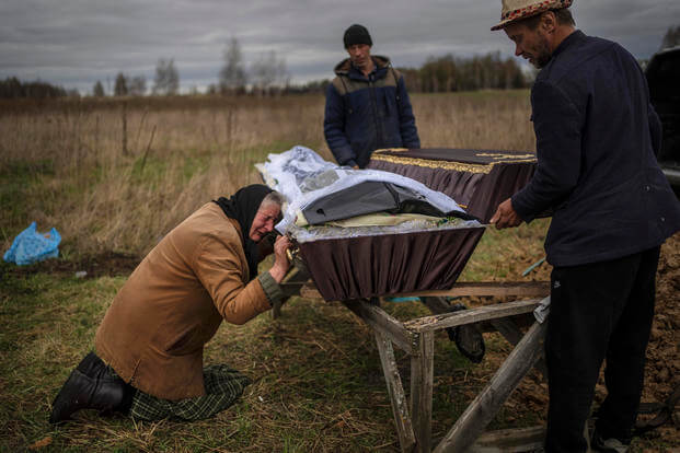 Ukrainian woman cries over the coffin of her son.