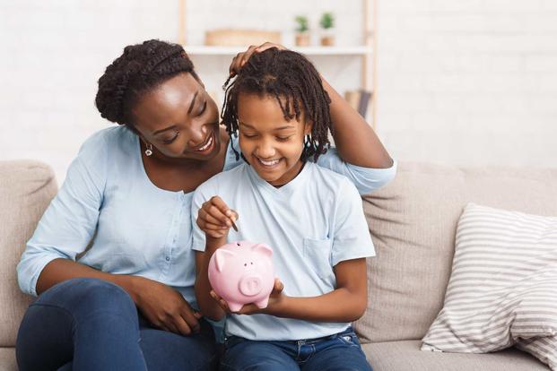 Mother and daughter saving money with piggybank