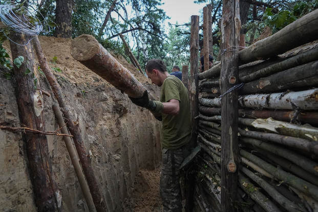 Ukrainian servicemen strengthen trenches on their position near the frontline in Kharkiv region