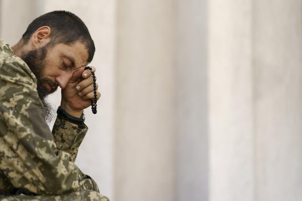 A Ukrainian serviceman prays during a service at St. Michael's Ukrainian Orthodox Church.