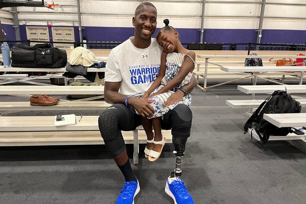 Warrior Games adaptive sports athlete Kevin Greene, an Air Force reservist, holds his 5-year-old daughter, Gianna. 