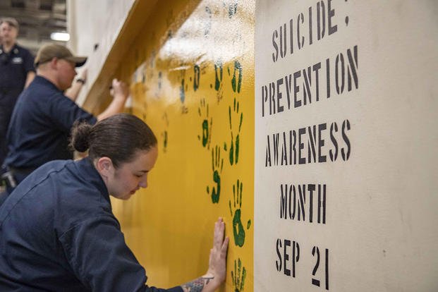 Gunner's Mate 2nd Class Alexis Vazquez places her handprint on the bulkhead of the vehicle stowage ramp aboard the amphibious transport dock ship USS Green Bay (LPD 20) in recognition of Suicide Awareness Month.
