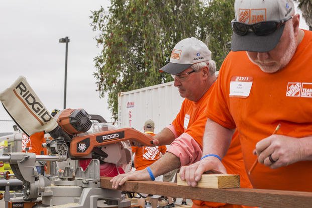 Volunteers with The Home Depot’s Building Materials department and their vendor partners cut wood to build benches during the K9 upgrade project aboard Camp Pendleton, California.