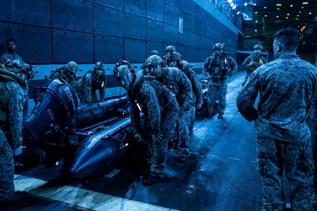 Marines carry a combat rubber raiding craft during a boat launch sustainment exercise