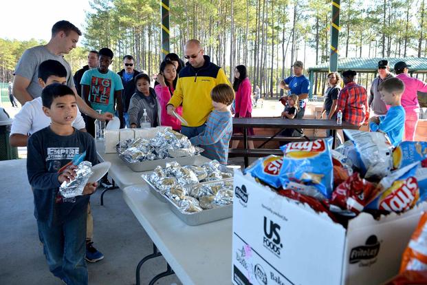 Team Shaw members line up and grab some food at a Fall Family Picnic.
