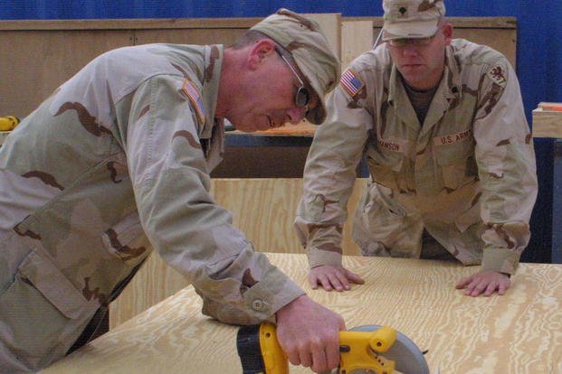 Sgt. Lee Hiller and Spc. Dan Abrahamson from the 1436th Engineer Company work together to build desks at self-help in Balad, Iraq.