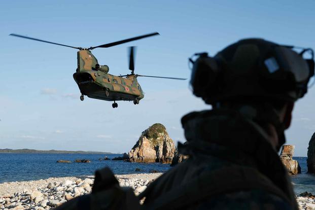 A Chinook helicopter departs after offloading Japanese and U.S. Troops.