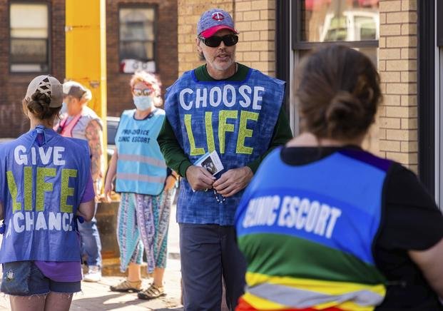 Anti-abortion protester attempts to talk to a clinic escort.