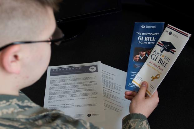 An airman reads pamphlets on the Montgomery GI Bill and the Post-9/11 GI Bill.