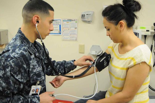 A corpsman checks the blood pressure of a patient.