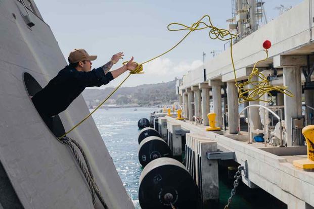 A sailor throws a line from the USS Montgomery.