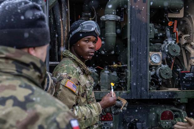 An Army petroleum supply specialist displays a fuel test pad.