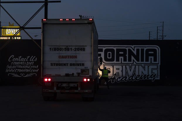 An evening class instructor gets off a practice truck after talking to his student at California Truck Driving Academy in Inglewood, Calif.