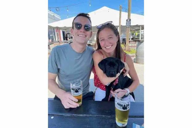 Cameron McMillan, pictured with his fiancé and their puppy.