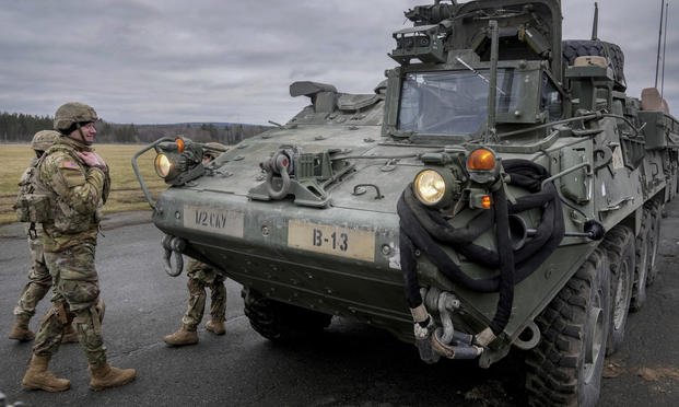 Soldiers stand next to a Stryker combat vehicle in Vilseck, Germany.