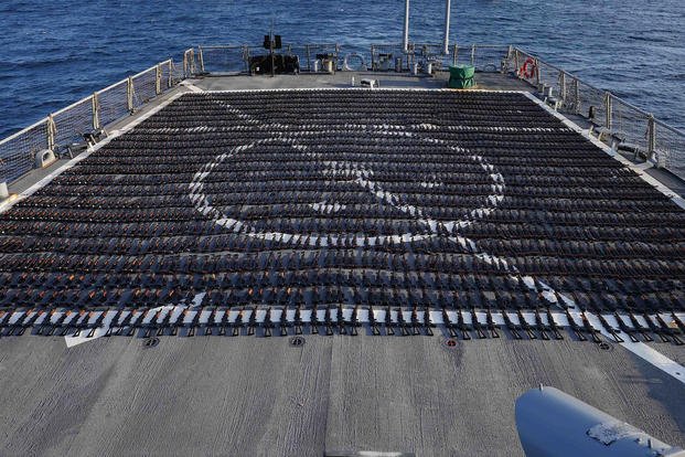 Thousands of AK-47 assault rifles sit on the flight deck of guided-missile destroyer USS The Sullivans