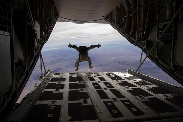 An Army paratrooper free falls out of a Marine KC-130J Hercules.