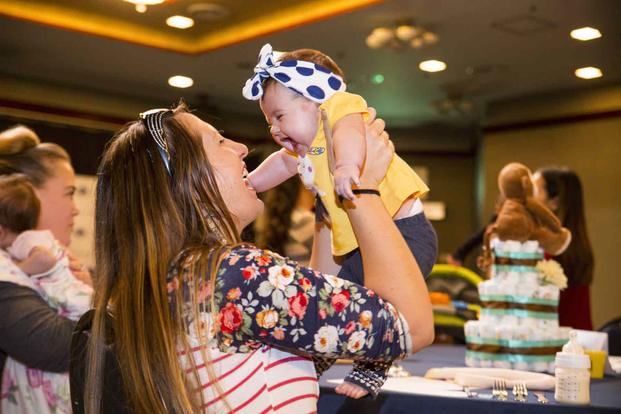 Mother plays with her daughter during the USO Special Delivery Baby Shower.