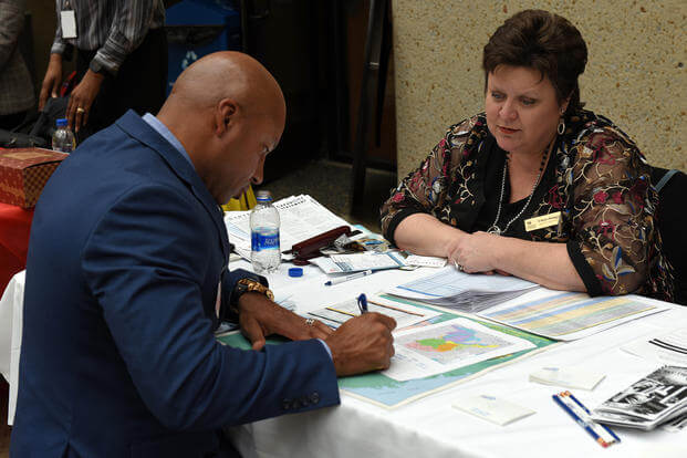 Eileen Hodges, U.S. Army Corps of Engineers Huntington District deputy for Small Business, provides contracting forecast info to Craig Stevens, president of Genesis 360 Construction in Baton Rouge, La., during the 9th annual Small Business Industry Day at Tennessee State University in Nashville, Tenn.