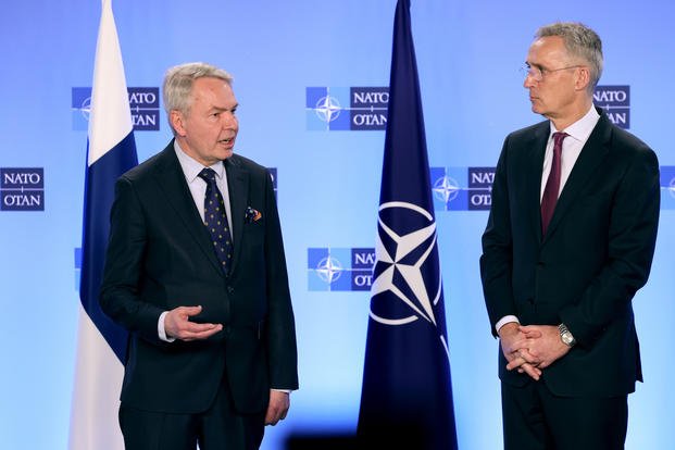 NATO Secretary General Jens Stoltenberg, right, speaks with Finland's Foreign Minister Pekka Haavisto