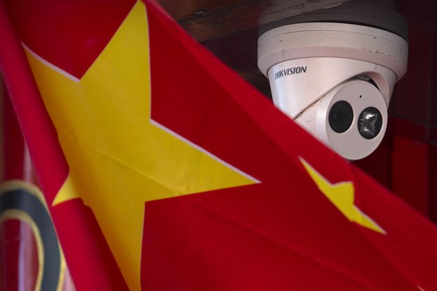 A Chinese flag hangs near a security camera outside of a shop in Beijing