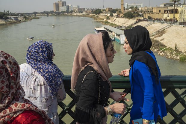 Women stand on the "martyrs' bridge" spanning the Tigris River in Baghdad, Iraq