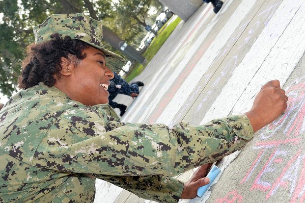 Chief Kareen Townsend, a sailor attached to Naval Hospital Jacksonville, Florida, uses chalk to write motivational words on the hospital sidewalk in honor of the National Disability Employment Awareness Month campaign, ‘Chalk the Walk.’ 