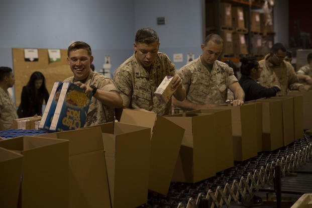 Marines fill cardboard boxes with non-perishable food items at the San Francisco Marin Food Bank.