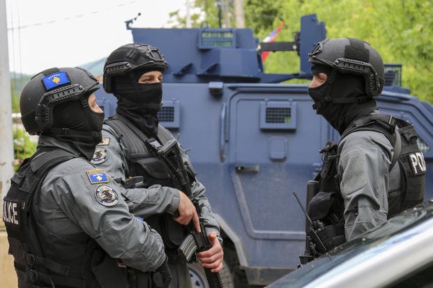 Kosovo police officers guard a municipal building.