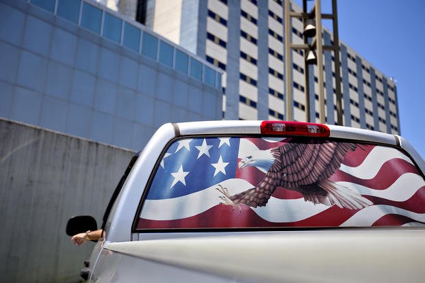 The back window of a pickup truck is decorated with an American flag as a motorist parks outside the Atlanta VA Medical Center.