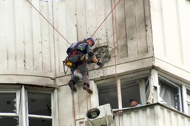In this image taken from video, investigators inspect the building after a Ukrainian drone damaged an apartment building in Moscow.