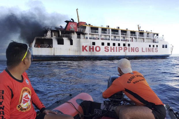 Philippine Coast Guard personnel assist in putting out the fire on ferry.