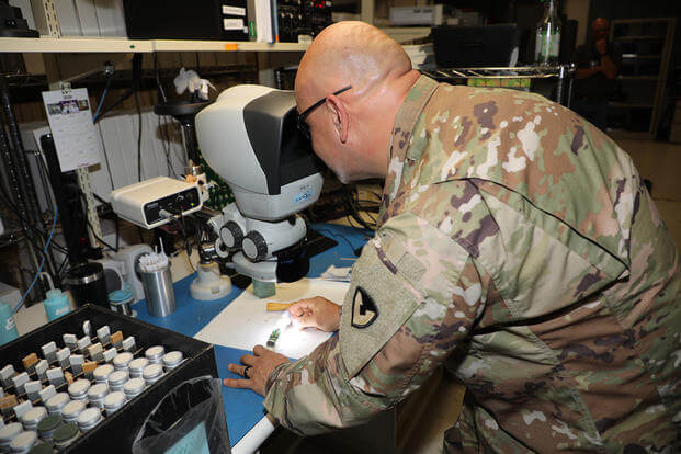 Chief Warrant Officer 3 Jesus Gonzalez inspects solder joints on a PATRIOT antenna element under a microscope as part of the Training with Industry (TWI) internship at Letterkenny Army Depot in Chambersburg, Pa.