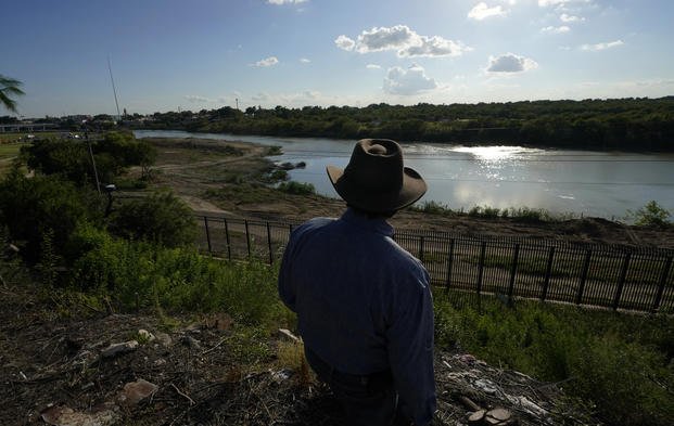 Kayak outfitter stands above the Rio Grande in Eagle Pass, Texas