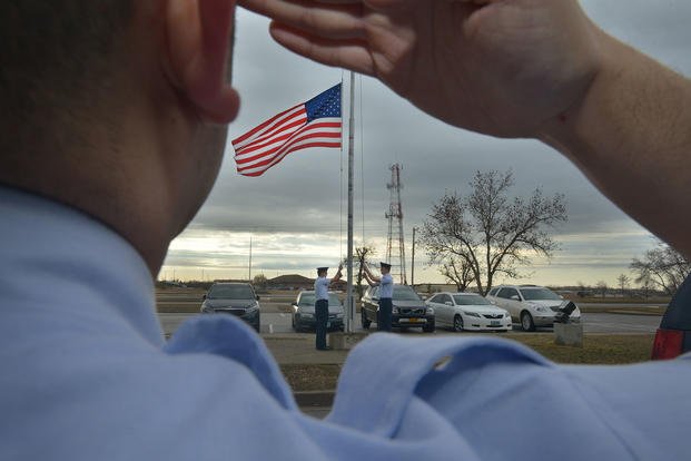 A guardsman from the 5th Force Support Squadron Honor Guard salutes a flag at Minot Air Force Base