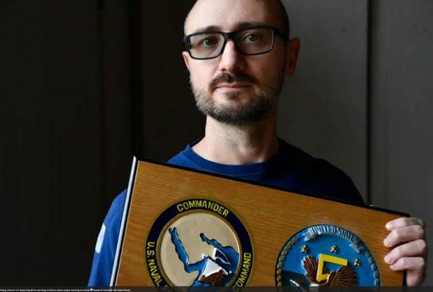 Jim Peckey, a former U.S. Navy petty officer now living in Abilene, Texas, holds a plaque honoring his military service. 