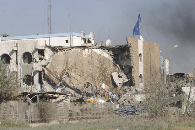 People inspect the rubble of the al-Canal Hotel after an explosion in Baghdad, Iraq, in 2003.