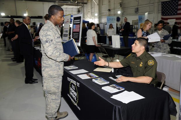 Airman 1st Class Onnie Mcspadden speaks with a representative of the U.S. Border Patrol during the Hiring Our Heroes job fair at Selfridge Air National Guard Base, Mich.