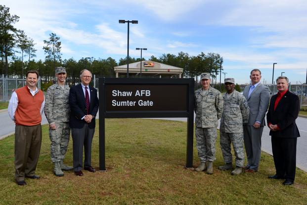 Team Shaw leadership, along with representatives from the city of Sumter, stand with the new sign in front of the Sumter Gate at Shaw Air Force Base, S.C., Dec. 3, 2015.