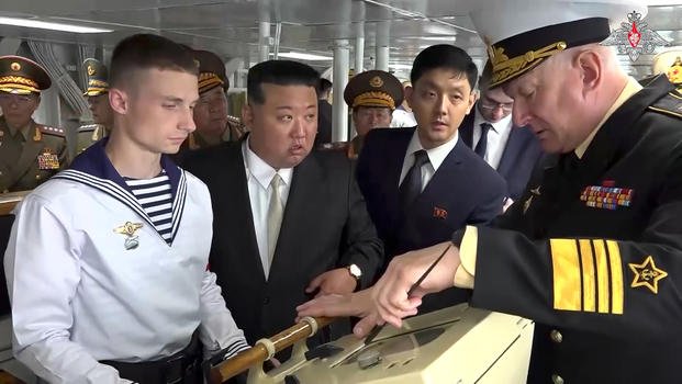 North Korea's leader Kim Jong Un listens to Russian Navy Admiral Nikolai Yevmenov.