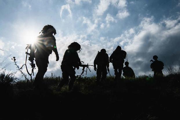 U.S. Army paratroopers climb a hill
