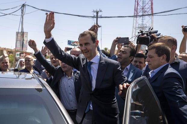 Syrian President Bashar Assad waves for his supporters